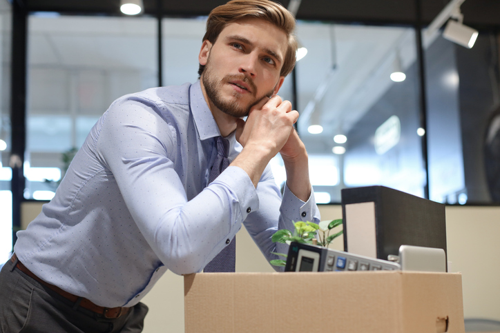 Sad dismissed worker are taking his office supplies with him from office. field-trip-health-layoffs-know-your-rights