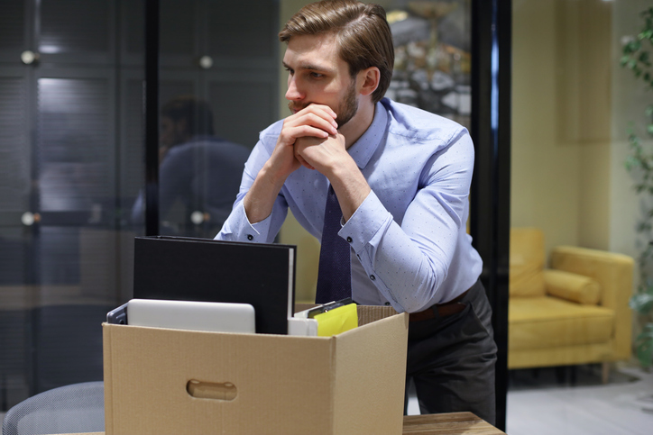 Dismissed worker going from the office with his office supplies. field-trip-health-layoffs-know-your-rights